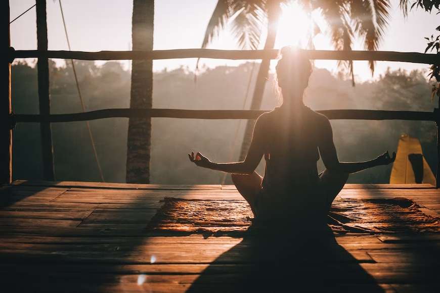 mujer disfrutando del amanecer haciendo posturas de yoga